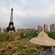 A farmer passes a replica of the Eiffel Tower in Tianducheng.